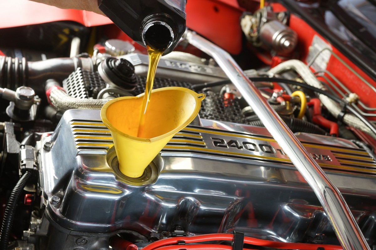 Oil going into a funnel in a car